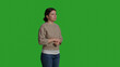 © DC Studio - Side view of person running late and checking time on wristwatch, being punctual and waiting on camera. Young adult worrying and being impatient, looking at watch over greenscreen background.