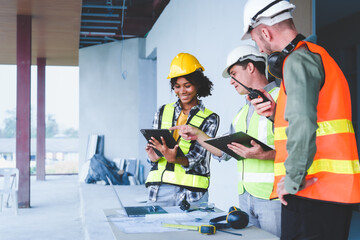 Wall Mural - Group of multi ethnic engineer construction site worker meeting at workplace, Architects working together at construction site to remodeling home or building. Working with laptop and tablet pc