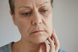 © evafesenuk - Close-up senior woman suffering from toothache, touching her cheek with her hand