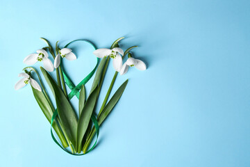 Wall Mural - Beautiful snowdrops and number 8 made of ribbon on light blue background, flat lay. Space for text