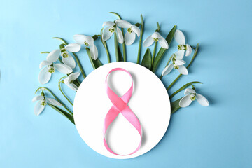 Wall Mural - Beautiful snowdrops, paper card and number 8 made of ribbon on pink background, flat lay