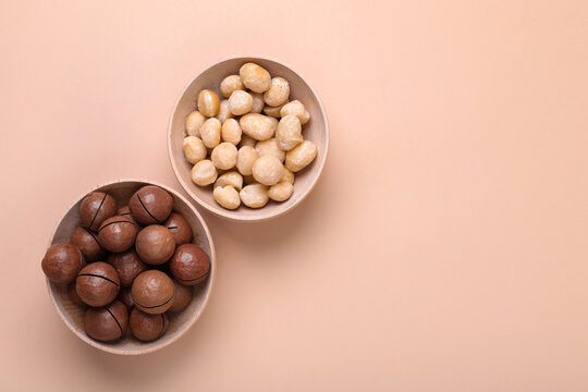 Wall Mural - Delicious organic Macadamia nuts on beige background, flat lay. Space for text