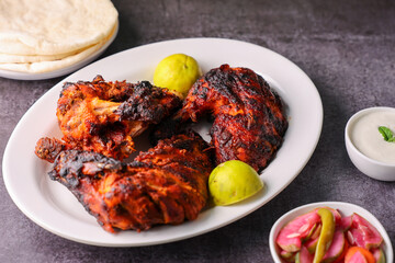 Wall Mural - A plate of full thandoori chicken. Arabian spicy food tandoori whole chicken Bengaluru India . Platter served with salads. Al Faham Charcoal Grilled Chicken .