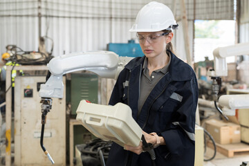 Aufkleber - Female engineer control robot arm by remote robot control in workshop. Woman technician working with control automatic robot arm system welding. Industry robot manufacturing technology