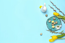Composition With Easter Quail Eggs, Pussy Willow Branches, Chamomile And Tulip Flowers On Blue Background