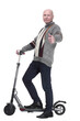 © ASDF - side view. mature man with electric scooter looking at you.