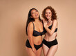 © gpointstudio - Two women in black underwear bonding and smiling towards the camera