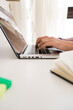 © Cavan Images - Cropped hands of editor using laptop computer on desk while working at home