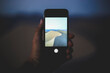 © Cavan Images - Cropped hand of tourist photographing sand dune with smart phone at Death Valley National Park during dusk