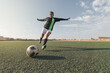 © Cavan Images - Young female soccer player kicking ball in a stadium.
