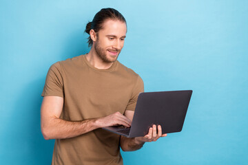 Photo of attractive programmer young man wear brown t-shirt freelancer hold laptop python program development isolated on blue color background