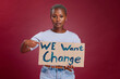 © Clayton D/peopleimages.com - Black woman, cardboard sign and protest for change, end racism and equality for people on studio background. Young girl, point to poster and human rights to fight against discrimination and gesture.