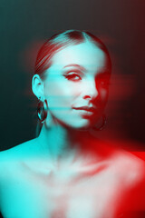 Beautiful woman portrait with make-up, classic hairstyle, naked shoulders and round earring standing in and looking at camera. Red and blue color split and 3D glitch virtual reality effect applied