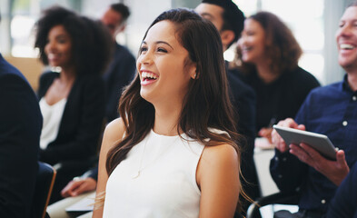 Poster - Opening the presentation with some in house humour. Shot of a happy young businesswoman sitting in the audience of a business conference.