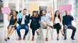 © Arcurs Co-op/peopleimages.com - Im the ideal candidate because...Shot of a group of businesspeople holding colorful speech bubbles while waiting in line in a modern office.