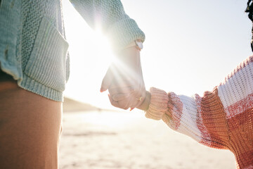 Canvas Print - Family, mother and child holding hands at beach, travel and summer with sunshine lens flare and together outdoor. Trust, support with woman and girl on vacation, love and care in nature with closeup