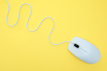 Wall Mural - White modern wired computer mouse on yellow background