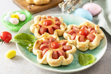 Idea for Easter breakfast or lunch. Mini pizza. Pizza in puff pastry with cheese and tomatoes on the festive table.