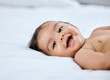 © Kay A/peopleimages.com - Im handing out smiles today, you want one. Shot of an adorable baby girl lying on a bed.