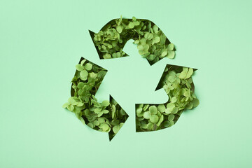 green flowers under paper cut recycling symbol. save planet recycling cloth concept