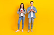 © deagreez - Full length photo of funky attractive best buddies wear jeans chatting twitter telegram facebook isolated yellow color background