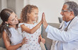 © A.S./peopleimages.com - Family, medical and high five with girl and doctor in consulting hospital room for healthcare, trust and support. Communication, medicine and smile with pediatrician consultant with mom and child