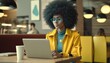 © MD Media - Happy stylish hipster African American teen girl with Afro hair using laptop computer in cafe, remote studying or working online.