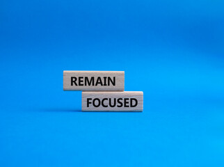 Remain focused symbol. Concept words Remain focused on wooden blocks. Beautiful blue background. Business and Remain focused concept. Copy space.