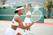 © Kay A/peopleimages.com - Stay fierce and fight for what you want. Shot of two sporty young women cheering while playing tennis on a court.