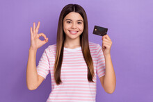 Photo Of Cute Sweet Girl Dressed Striped T-shirt Showing Okey Sign Rising Credit Card Isolated Purple Color Background