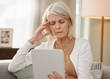 © Kay A/peopleimages.com - Dear Internet, what do I do about this headache. Shot of a mature woman using a digital tablet and feeling unwell at home.