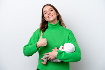 Wall Mural - Young caucasian woman with her cute baby isolated on white background with thumbs up because something good has happened