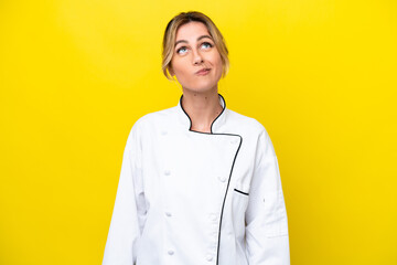 Sticker - Uruguayan chef woman isolated on yellow background and looking up