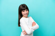 © luismolinero - Little caucasian girl isolated on blue background with arms crossed and looking forward