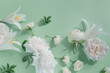 Creative summer composition made of rose and lily flowers on pastel green background. Beautiful floral layout. Nature concept. Top view. Flat lay