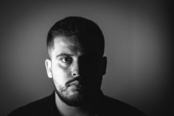 Grayscale portrait of a young Caucasian male with a serious face