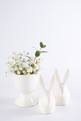 home interior with easter decor. cute little rabbits and flowers on white background.