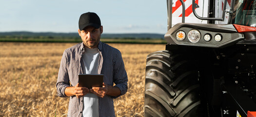 Sticker - Farmer with digital tablet on a background of combine harvester. Smart farming concept.	