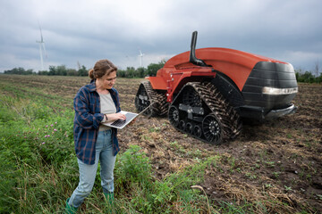 Sticker - Woman farmer with digital tablet controls an autonomous tractor on a smart farm	