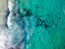 Aerial View Of People Doing Surf In The Ocean At Camps Bay, Cape Town, South Africa.