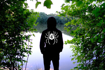 evening landscape with forest lake, river, back young man, teenager, intruder standing in black hood and looking pond, water surface, mysterious mystical landscape, mystical, background for designer