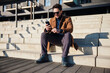 © baranq - Happy man relaxing on stairs reading message on his phone during sunny spring day in the city