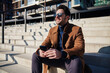 © baranq - Handsome man enjoying sunny winter or spring day in the city relaxing on stairs