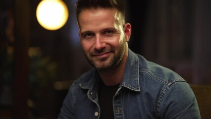 Poster - Portrait of happy confident young man at home in dark room, smiling.