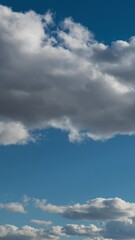 Wall Mural - Vertical time lapse of blue sky, big and small clouds over horizon
