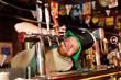 © AvokadoStudio - ginger guy tries to drink beer from the faucet behind the bar