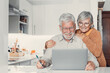 © Daniel - Old age and modern tech. Retired family couple sit at kitchen table use laptop watch photo video read latest news online. Aged husband share discuss interesting information on website with senior wife