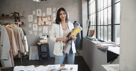 Wall Mural - Portrait of successful Asian female clothes designer at her office, woman looking at camera and smiling. - women empowerment, job equality, fashion concept