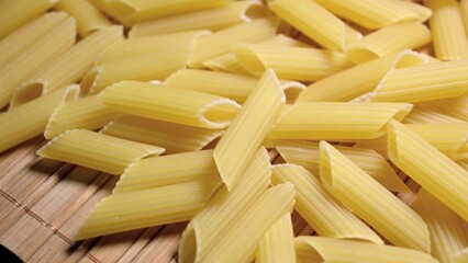 Wall Mural - sliding footage uncooked penne pasta closeup