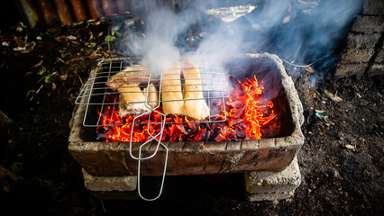 pork being grilled on coals